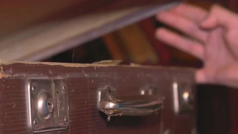 The man closes an old battered brown suitcase. Stock Footage 137738453