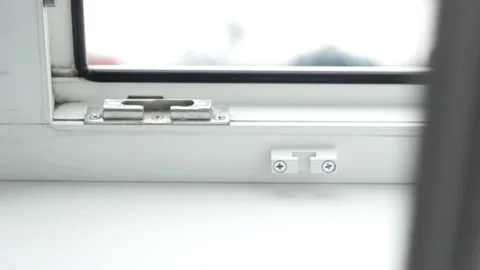 A man closes the pvc window and closes the child lock on the window, security Video stock 103684041