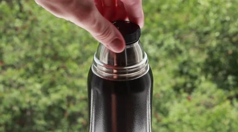 Man closes a thermos Stock Footage 64622973