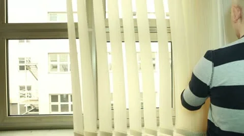 Man closing and turning vertical blinds on the office window Stock Footage 22280828