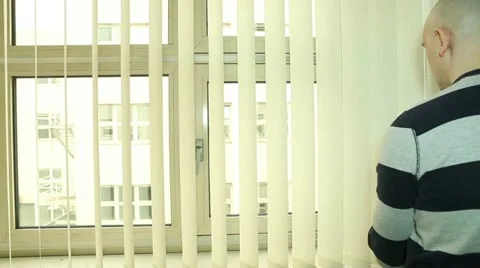 Man closing and turning vertical blinds on the office window Stock Footage 22282137