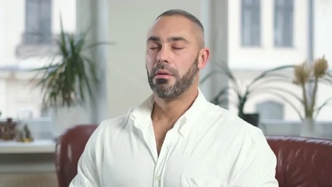 Man with closing eyes taking a deep breath after hard work, wearing white shirt Stock Footage 148556849