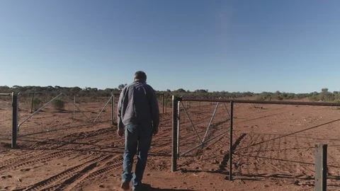 Man closing farm gate in outback Australia Stock Footage 92522339