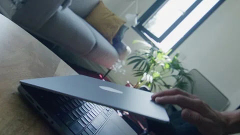 Man closing laptop computer on table at home Stock Footage 307601869