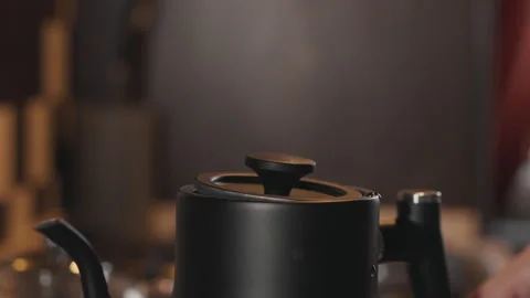 Man closing the lid of a boiling kettle with steam Stock Footage 294234174