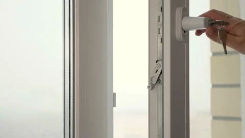 A man closing a window with a key 库存影片 126710847
