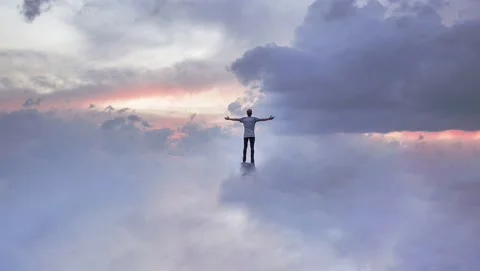 Man in clouds with arms out in victory and praise Stock Footage 169097961