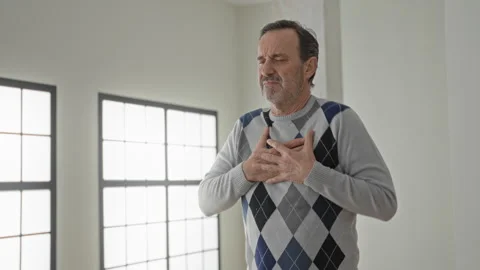 Man clutch chest with hand pressed to heart, grimace signaling arrest in bu.. Stock Footage 337444465