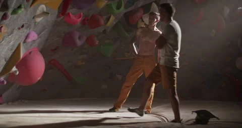 Man coach discussing with guy climber in gym Stock Footage 259985494