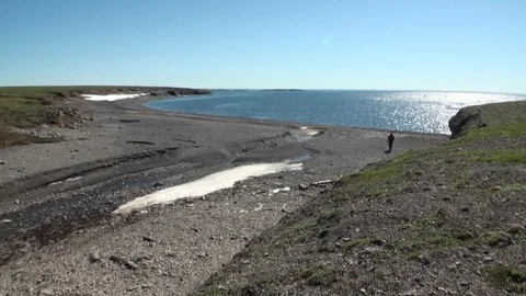 Man on coast and water surface of Arctic Ocean on New Earth Vaigach Island. Stock Footage