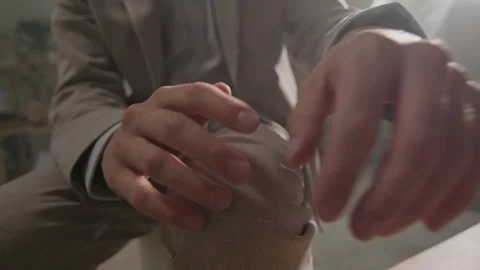 Man with coat holding hands while sitting in a stylish indoor setting Stock Footage 319955657