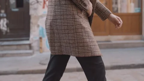 A man in a coat is walking down the street. Walk in the city center Video stock 243826664