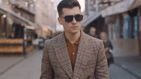 A man in a coat is walking down the street. Walk in the city center Video stock 243826693