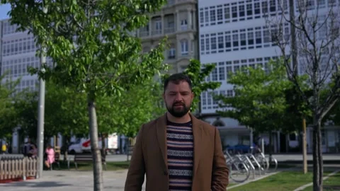 A man in a coat walks forward to the camera, speaking out loud. A businessman Stock Footage 220320791