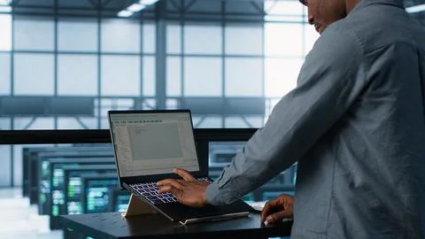 Man coding on data center, testing failover scenarios using notebook Stock Photos