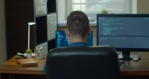 Man coding html and programming on two screen Monitors, development web Stock Footage 129448895