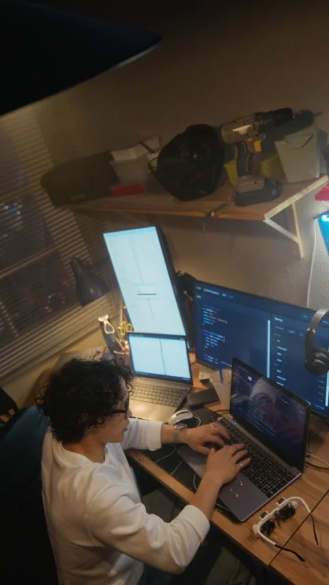 Man Coding on Laptop with Multiple Screens in Home Office at Night Stock Footage 338421858