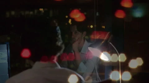 Man coding at night in technology office, with glowing desk lamp and floating Stock Footage 307829054