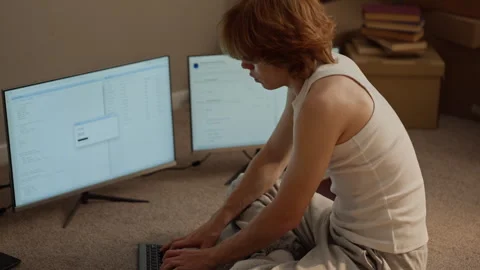 Man Coding Software on Multiple Computer Screens at Home 库存影片 346605499