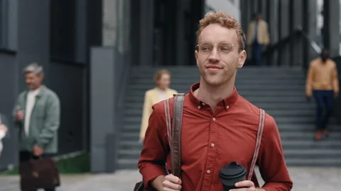 Man with coffee and bag walking near office center Stock Footage 168227135
