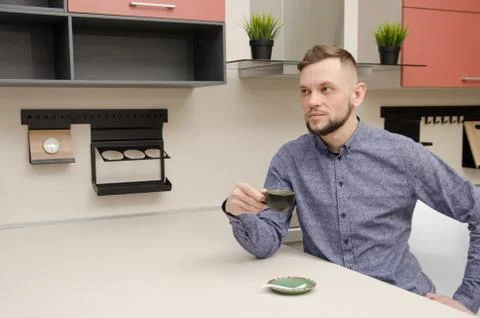 Man with coffee cup at the table in modern kitchen Stock Photos