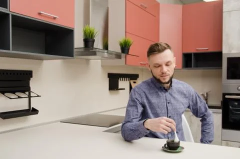 Man with coffee cup at the table in modern kitchen Stock Photos