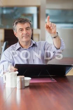 Man in a coffee shop calling a waiter Stock Photos