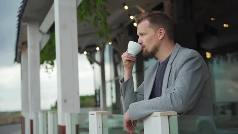Man with coffee thinking on balcony Video stock 111757289
