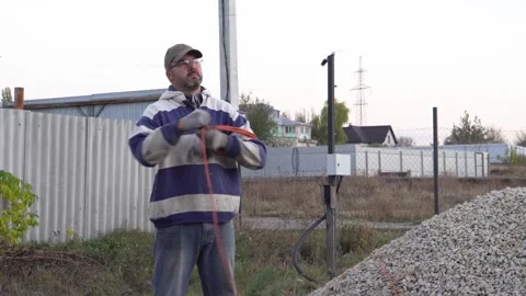 A man coiling an electrical cord 4K Stock Footage 294049210