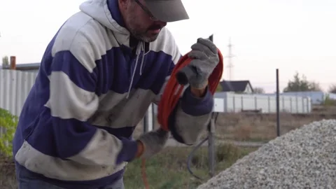 A man coiling an electrical wire 4K Video stock 294049507