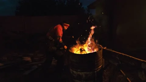 A man is cold and warming himself by the fire at night. Stock Footage 238479296
