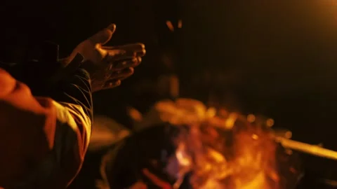 A man is cold and warming himself by the fire at night. closeup hands. Stock Footage 238479497