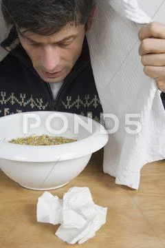 A man with a cold breathing steam from a bowl Stock Photos