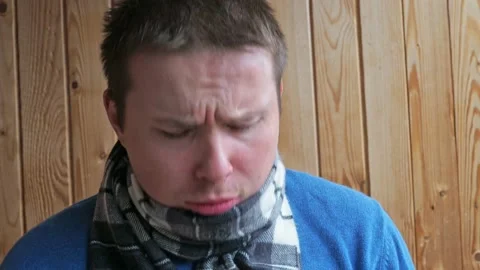 A man with a cold coughs and blows his nose into a handkerchief. dressed in a Stock Footage 166110976