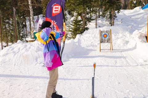 A man with a cold weapon in his hands aims at a target, holds a bow in his .. Stock Photos