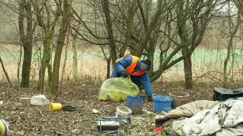 Man collect garbage nad rubbish gathers bag, forest black dump waste Stock Footage 101931663