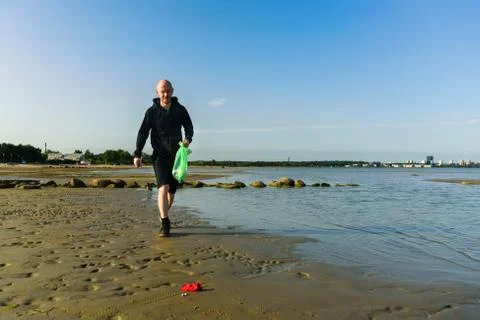 Man collecting garbage on beach Stock Photos
