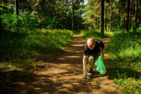Man collecting garbage in forest Stock Photos