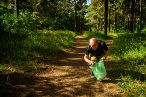 Man collecting garbage in forest Stock Photos