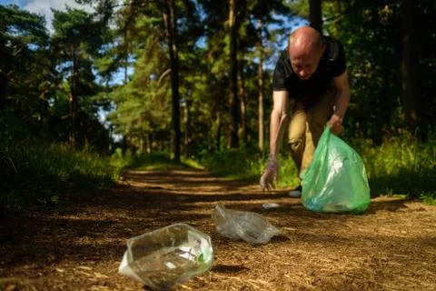 Man collecting garbage in forest Stock Photos
