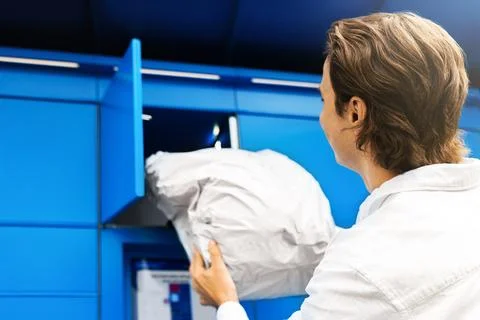 Man collecting a package from a blue parcel locker. Convenient contactless .. Фото