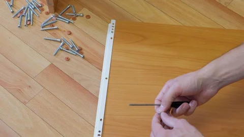 Man collecting parts of computer table screwing sliding mechanism screwdriver. Stock Footage 124859799
