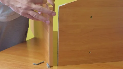 Man is collecting parts of computer table screwing shelf screwdriver, closeup. Stock Footage 124859972