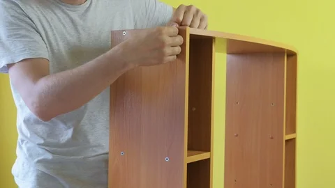 Man is collecting table and covering bolts with plastic details, hands closeup. Stock Footage 124861145