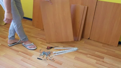 Man is collecting table in room taking parts using instructions, closeup view. Stock-Footage 124894060