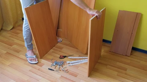 Man is collecting table in room taking parts using instructions, closeup view. Stock Footage 129418042