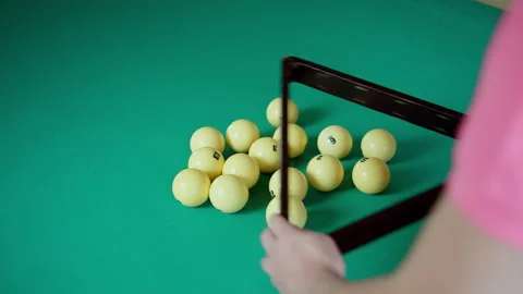 Man in a collects billiard balls in a triangle on a felt table, Russian billiard Stock Footage 309856385