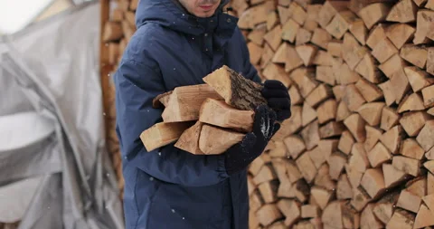 Man collects firewood from stack outdoors in winter. Weather concept. Stock Footage 326328991