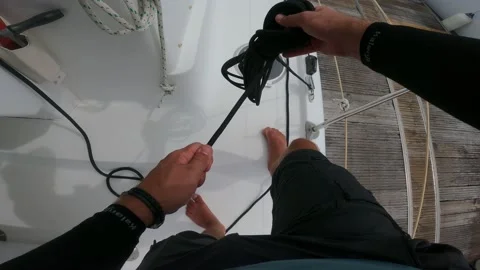 A man collects ropes in a bay while working on a sailing catamaran, yachting pov Stock Footage 219781609