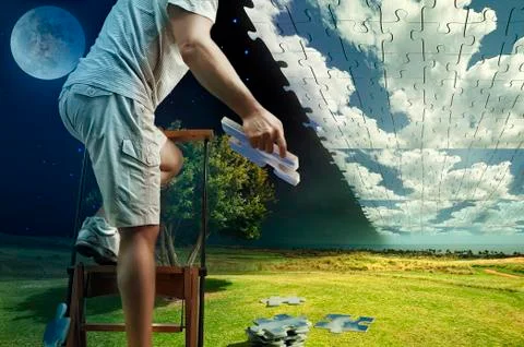 Man collects the sky from puzzles while standing on the ladder Stock Photos